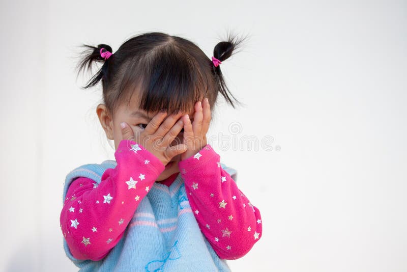 Cute asian baby girl closing her face and playing peekaboo or hide and seek with fun. Cute asian baby girl closing her face and playing peekaboo or hide and seek with fun